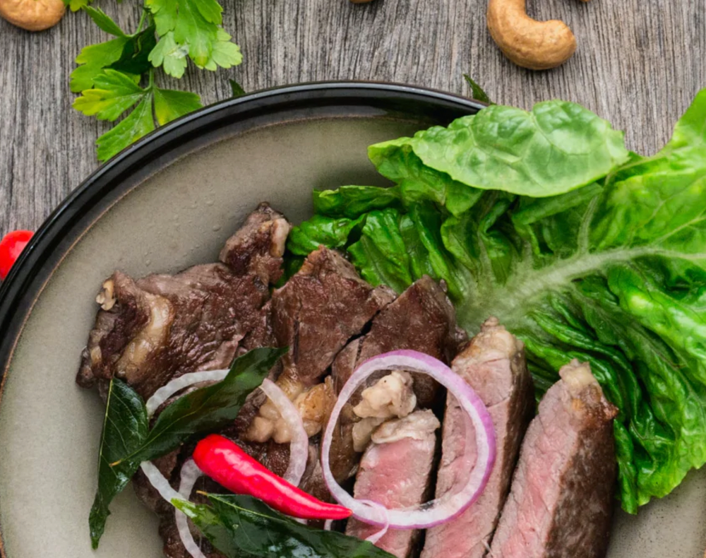 Protein-rich steak on a plate with salad and nuts